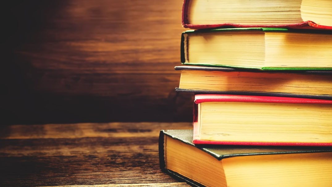 stack of books on the dark wood background. toning. selective focus on the middle book